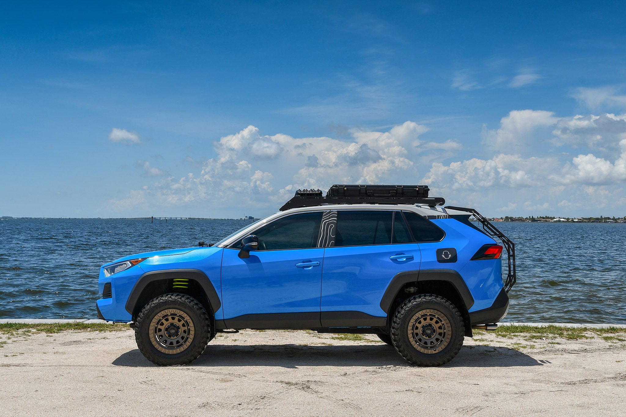 overland sector wheels rig gallery kj's toyota rav4 off-road trail on 17x9 satin bronze venture wheels 3 inch lift 32 inch tires custom bumper roof rack roof cases on water