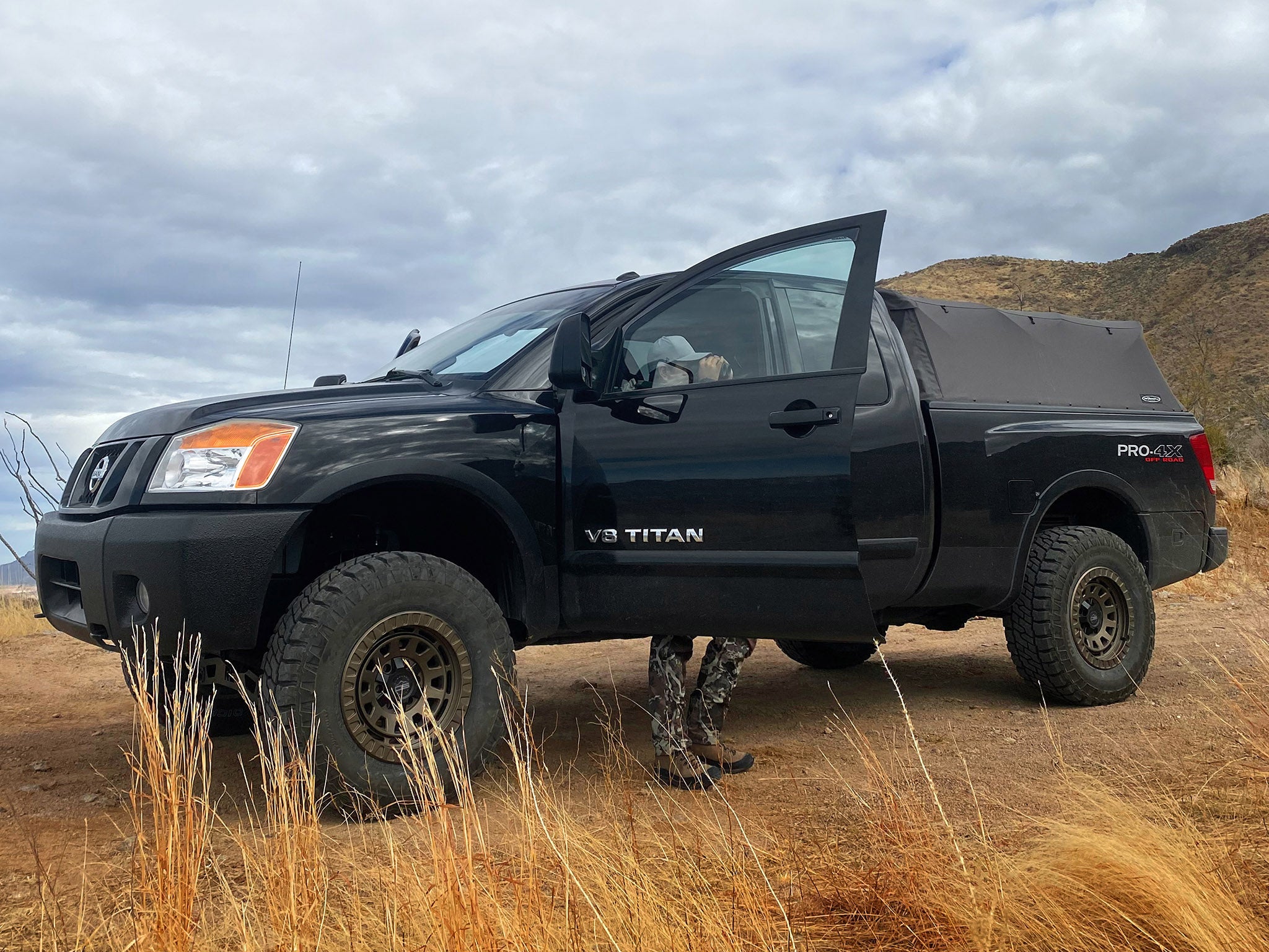 overland sector wheels Nissan Titan Pro 4x lifted on 17x9 satin bronze venture wheels on dirt trail in desert
