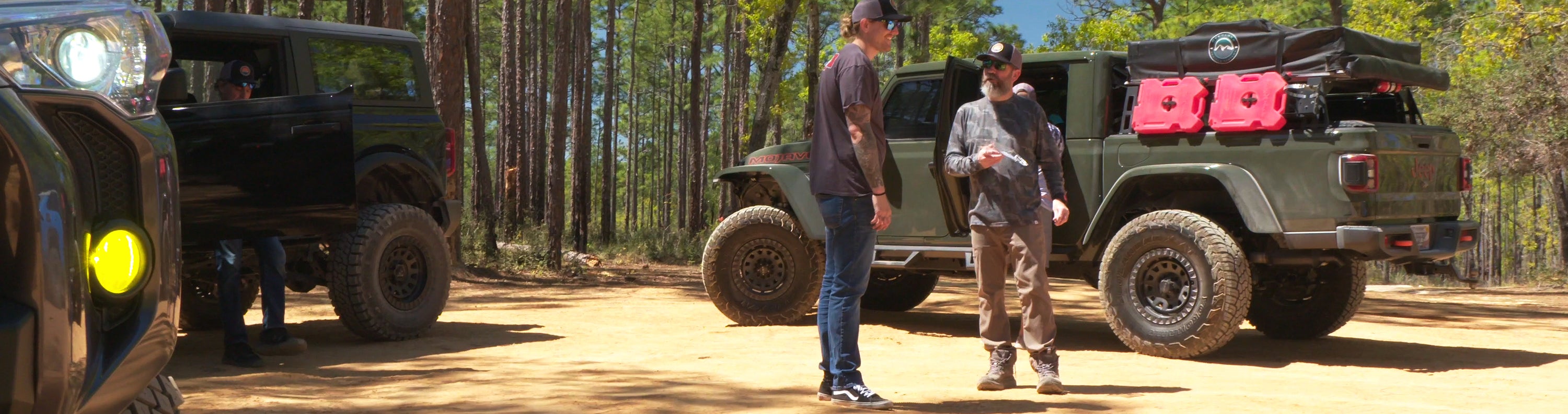 overland sector wheels off-road three vehicles on the trail toyota 4runner ford bronco jeep gladiator mojave clay dirt trail talking back at basecamp