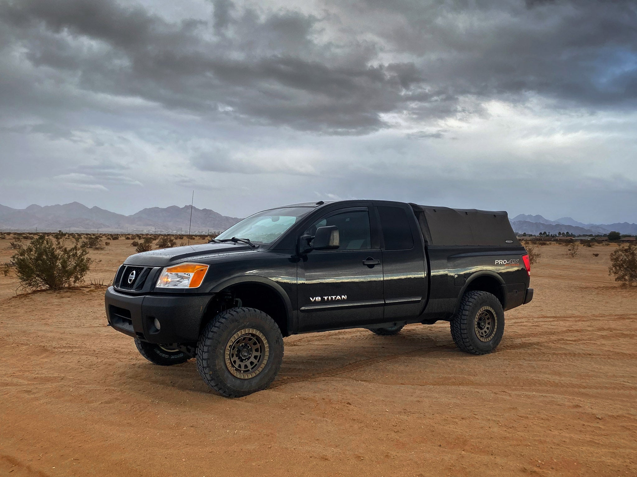overland sector wheels Nissan Titan Pro 4x lifted on 17x9 satin bronze venture wheels on dirt trail in desert