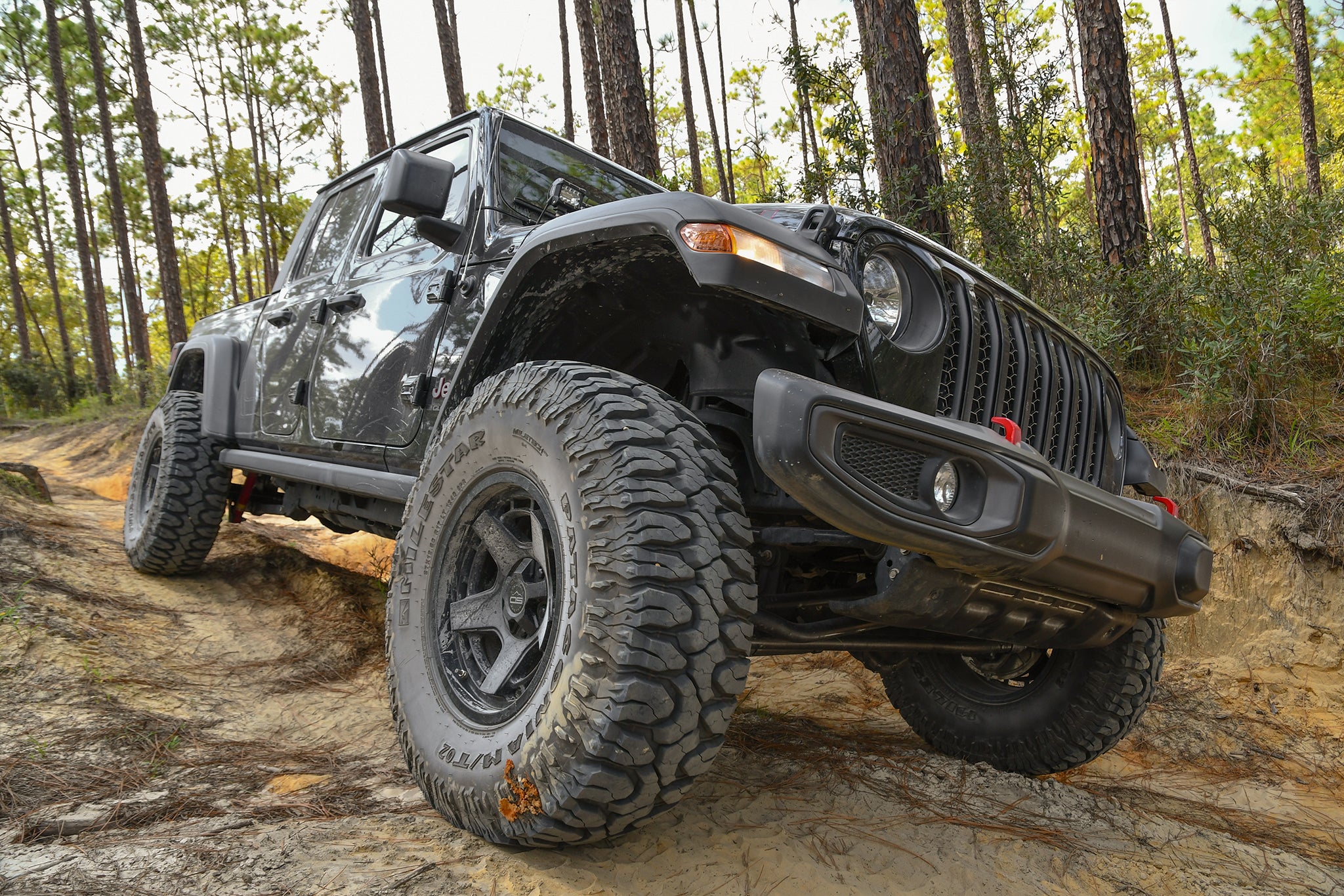 overland sector wheels jeep gladiator rubicon on 17x9 satin black atlas wheels on dirt trail in woods